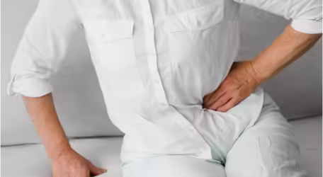 a man hold his side in pain