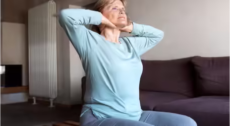 A woman exercising holding the neck.