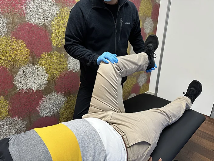 Physiotherapist performing leg stretch on patient during physical therapy session