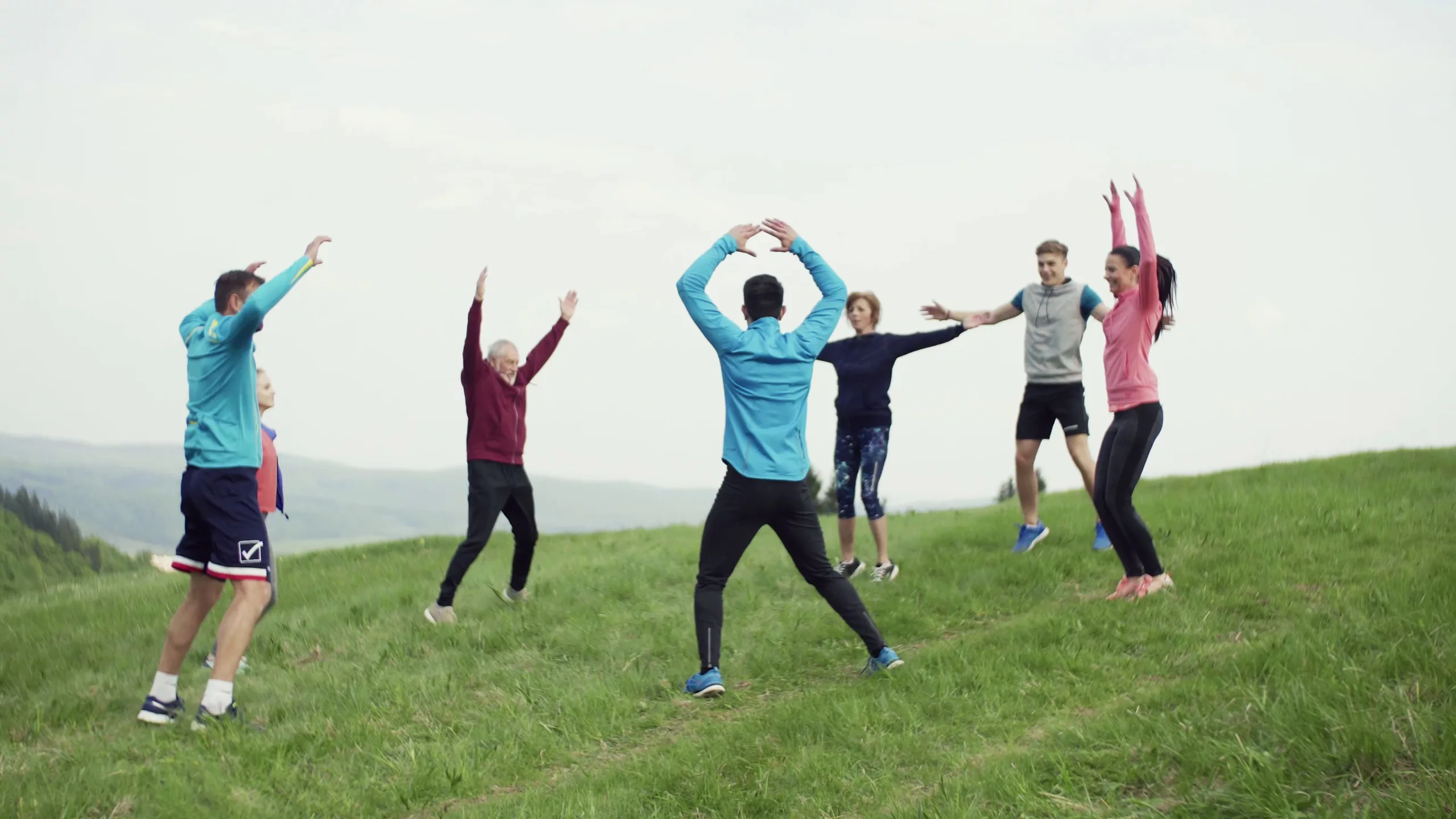 a large group of fit and active people doing exercise in nature